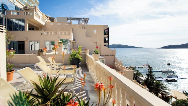 A hotel with balconies overlooking a marina and sea. - New Hotel Kuc By Marvel (Becici)