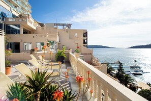 Un hôtel doté de balcons donnant sur une marina et la mer.