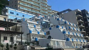 A multi-story hotel with balconies, a rooftop terrace, and a restaurant. - New Hotel Kuc By Marvel (Becici)