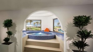 Een moderne spa met een jacuzzi, houten sauna en potplanten.