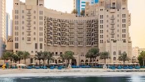 Un hotel grande con varios pisos y balcones, ubicado junto a la costa.