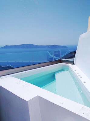 A modern infinity pool with a clear view of the sea and distant islands. - Smaro Studios (Santorini)