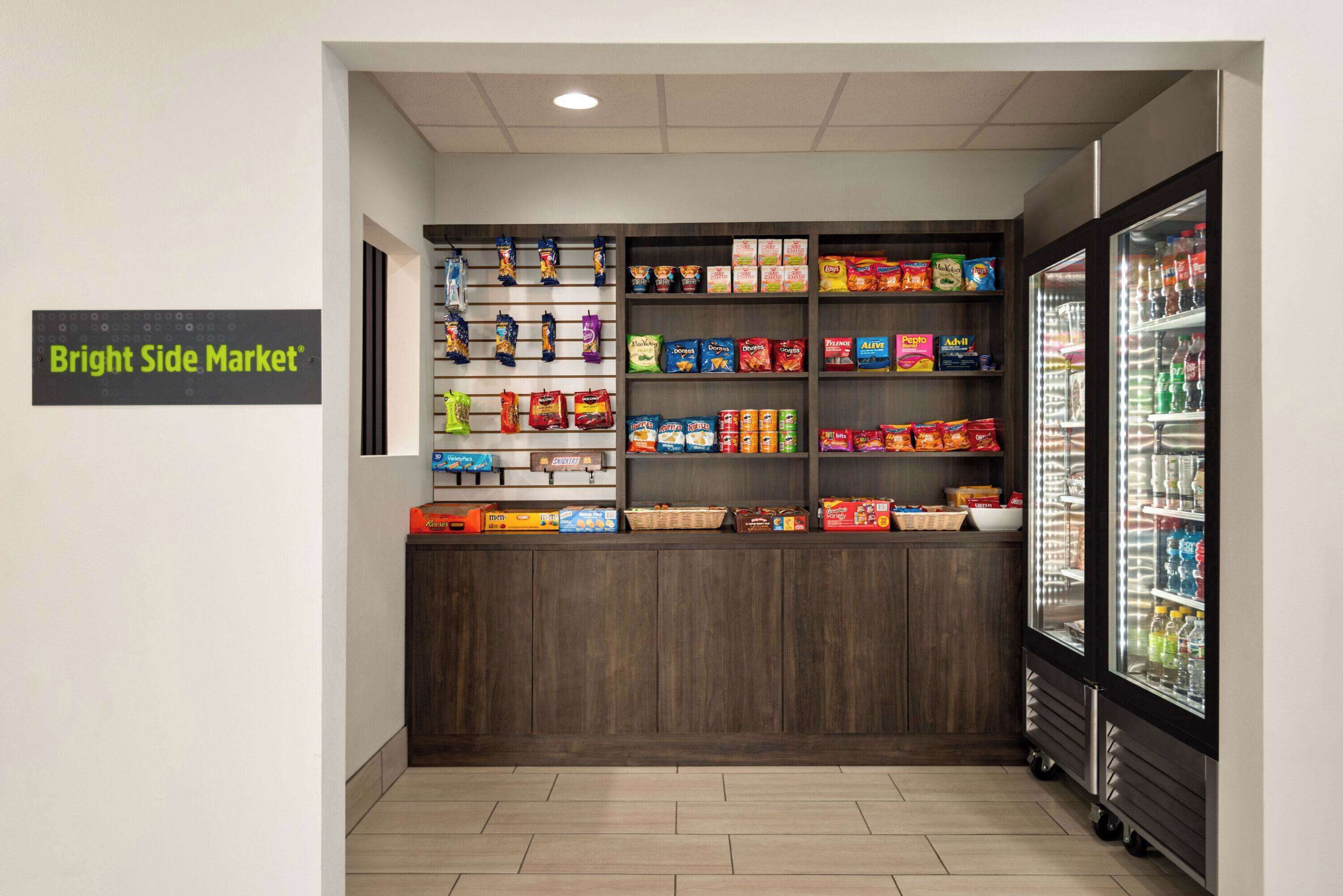 A snack and beverage kiosk with various packaged goods and a refrigerated display.