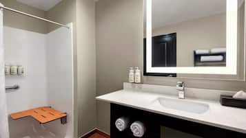 A modern bathroom with a shower, a sink, a mirror, and a towel rack.