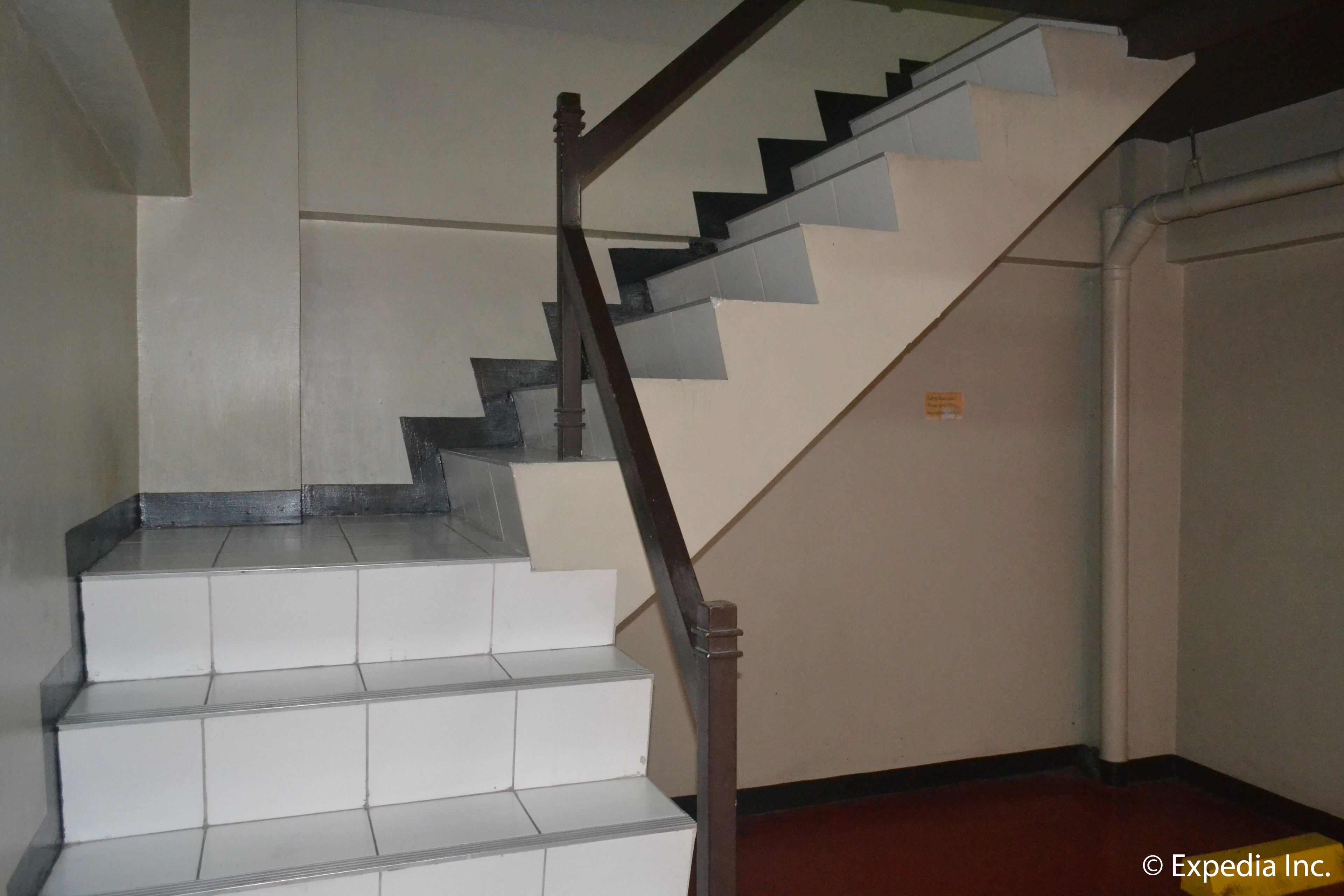 A staircase with white steps and a wooden handrail.