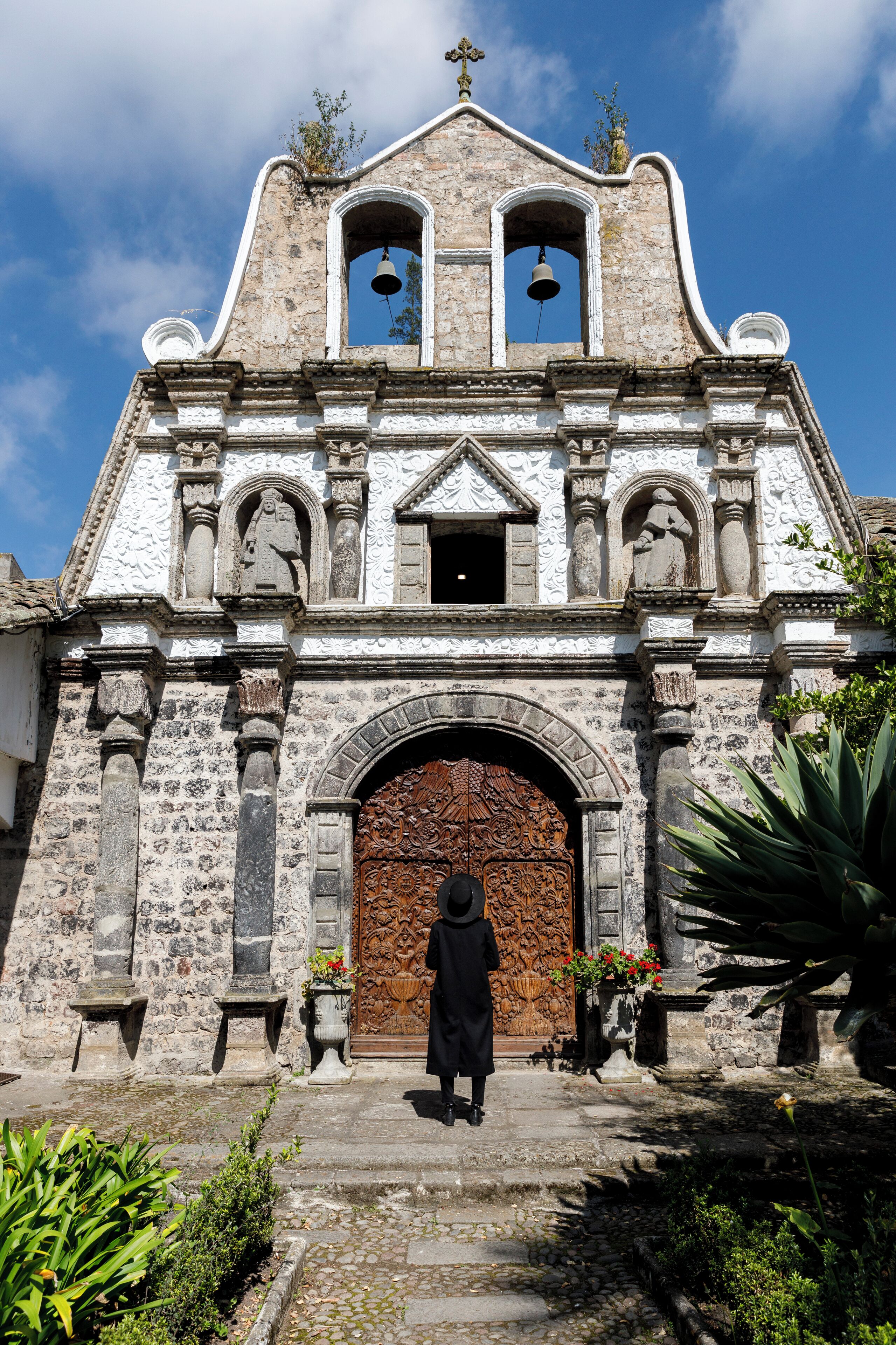 A historic church with a wooden door, stone columns, and a bell tower.
