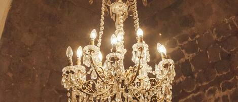 Un lustre à plusieurs lampes suspendu à un plafond en pierre.