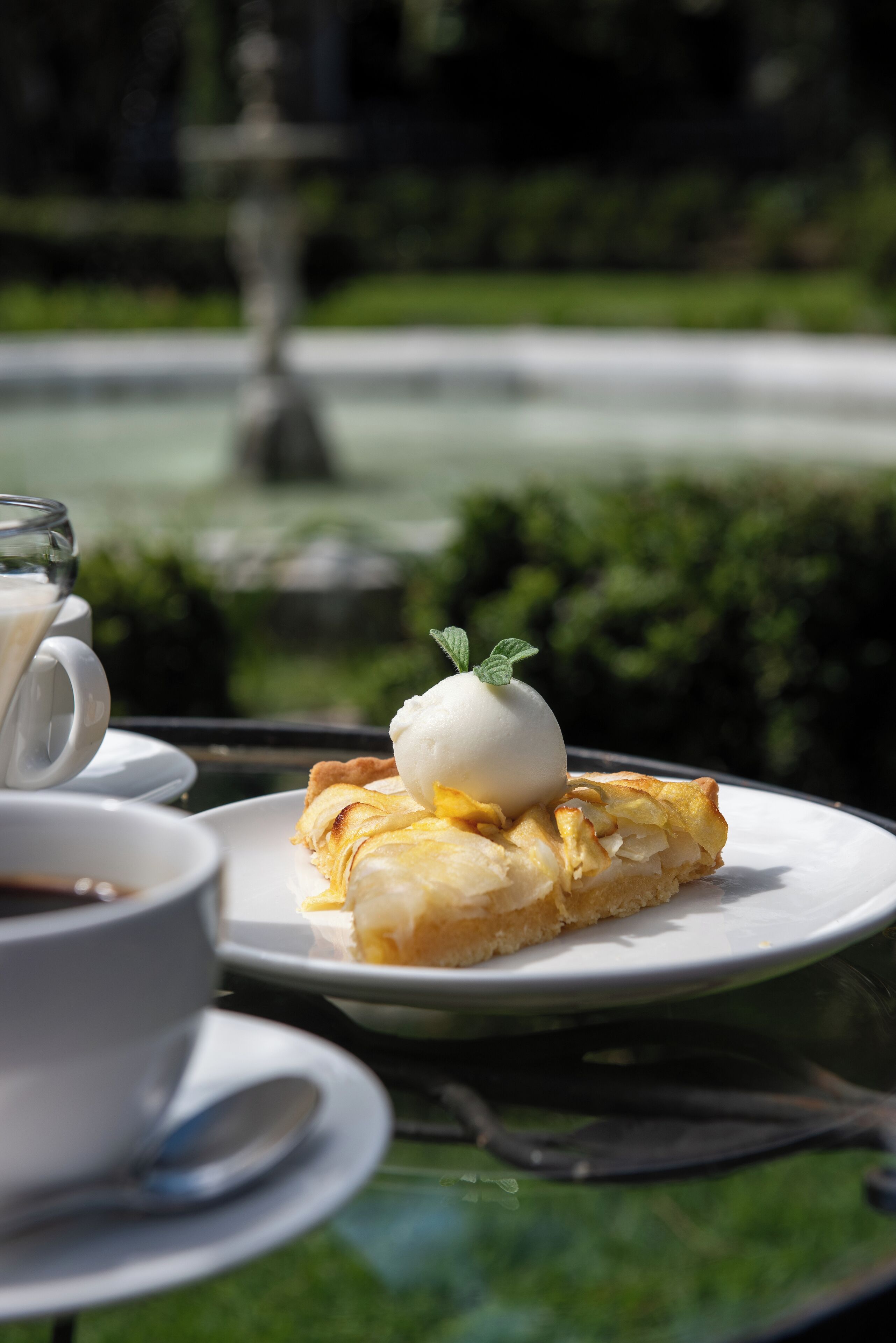 Una mesa con un plato de comida, una taza de café y una cuchara.