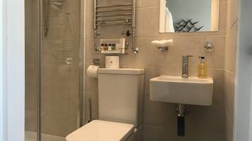A bathroom with a toilet, a sink, and a shower.