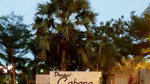 Señal del Pranburi Cabana Resort con una piscina al frente.