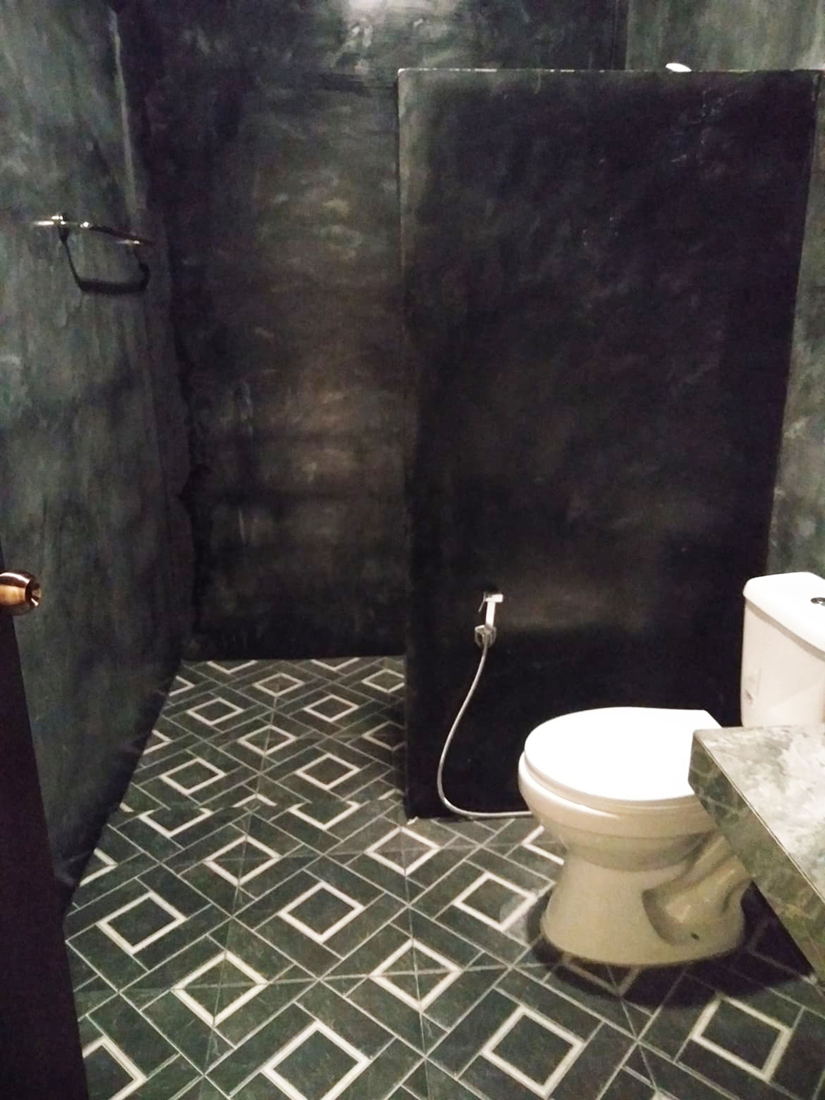 A bathroom with a toilet, a shower stall, and a sink.