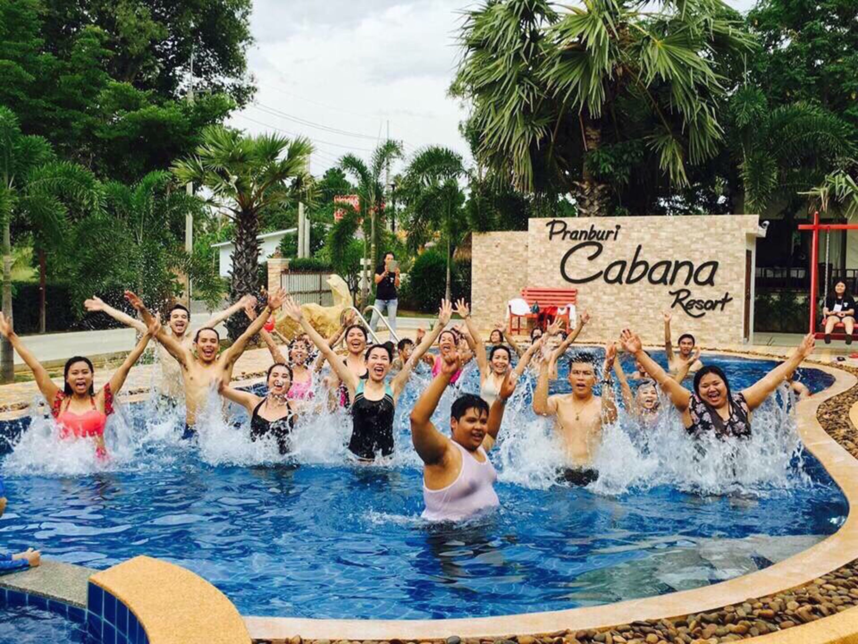 A group of people enjoying a pool at Pranburi Cabana Resort.