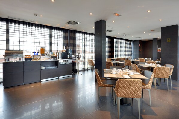 A modern dining area with a central island, cushioned chairs, and a long counter with kitchen appliances.