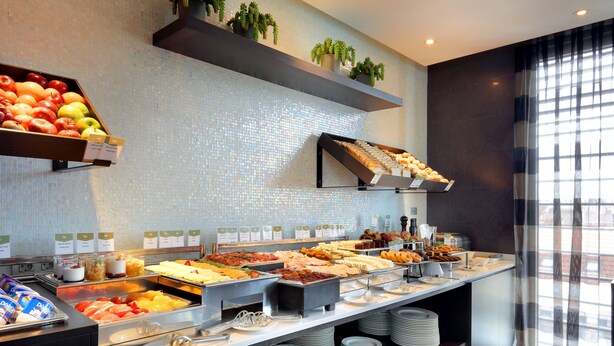Un buffet proposant une variété de plats et une présentation de fruits.