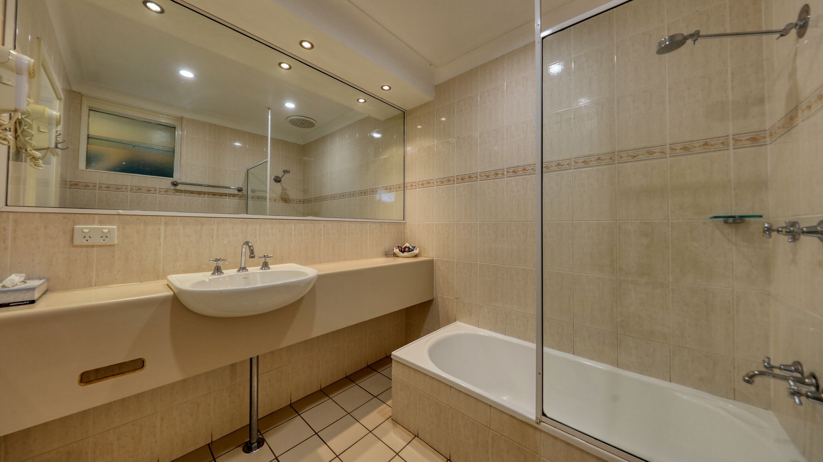 Une salle de bain moderne avec un double vasque, une baignoire et une cabine de douche en verre.