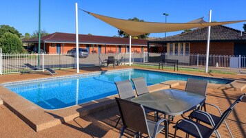 Una piscina al aire libre, tumbonas