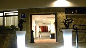 Ein Hotelzugang mit Steinwänden, einer Treppe und einem einsehbaren Empfangsbereich.