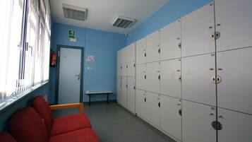 A room with lockers, a bench, and a door.
