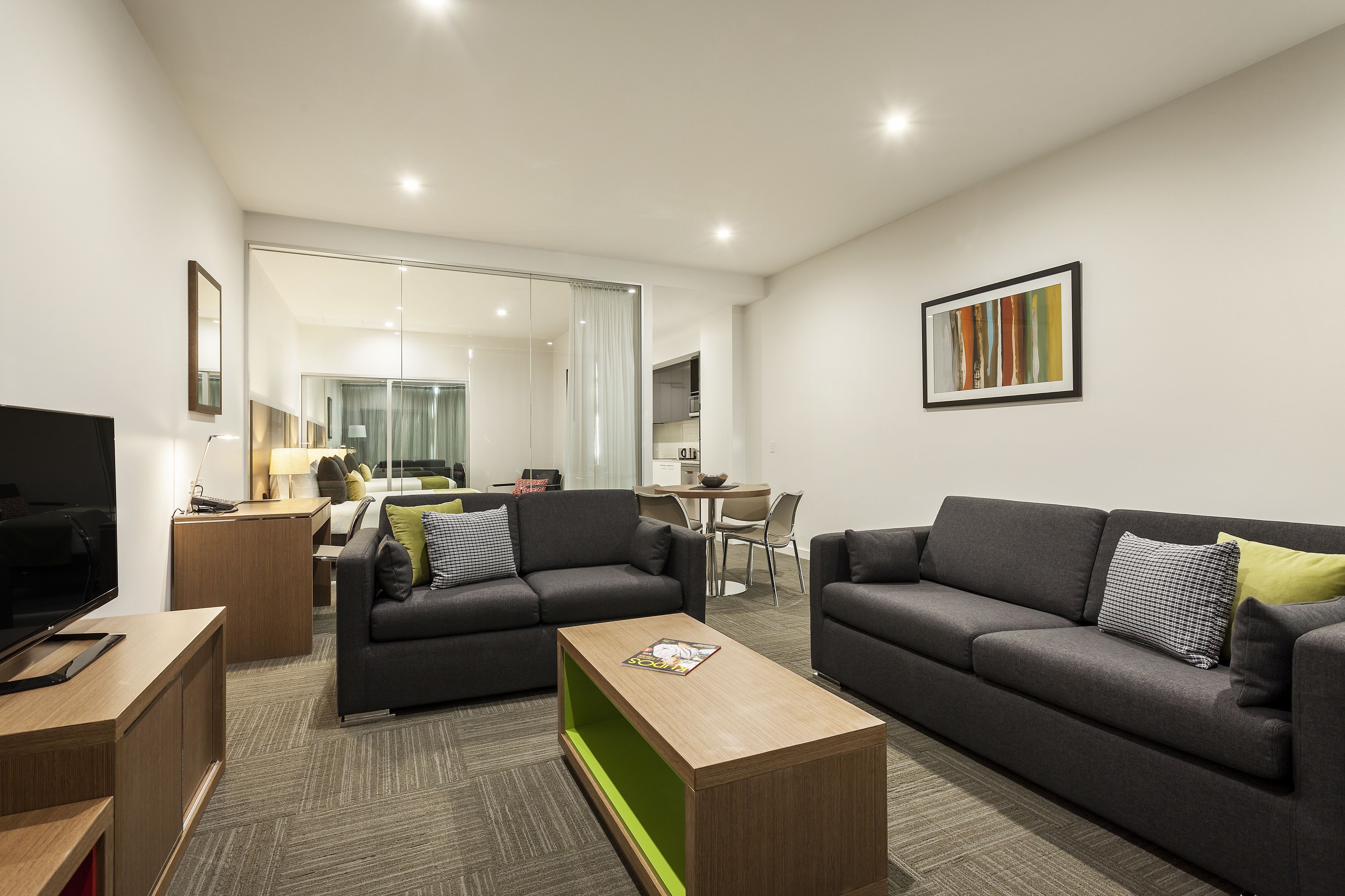 A modern living room with two sofas, a coffee table, and a TV.