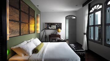 Un dormitorio ordenado con una cama, un escritorio con un globo terráqueo y un ventanal con persianas.