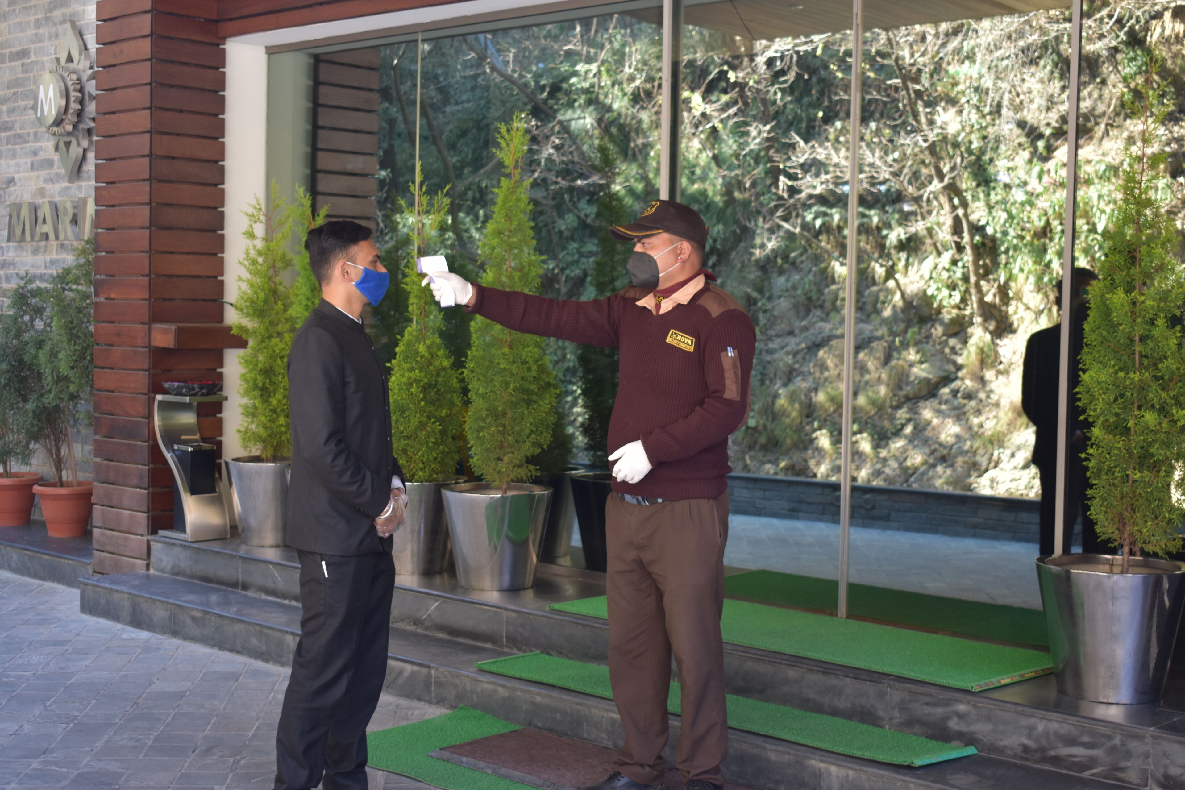 Una persona con uniforme toma la temperatura con un aparato.