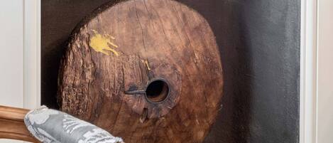 A wooden object with a circular hole and a yellow mark, placed against a dark background.