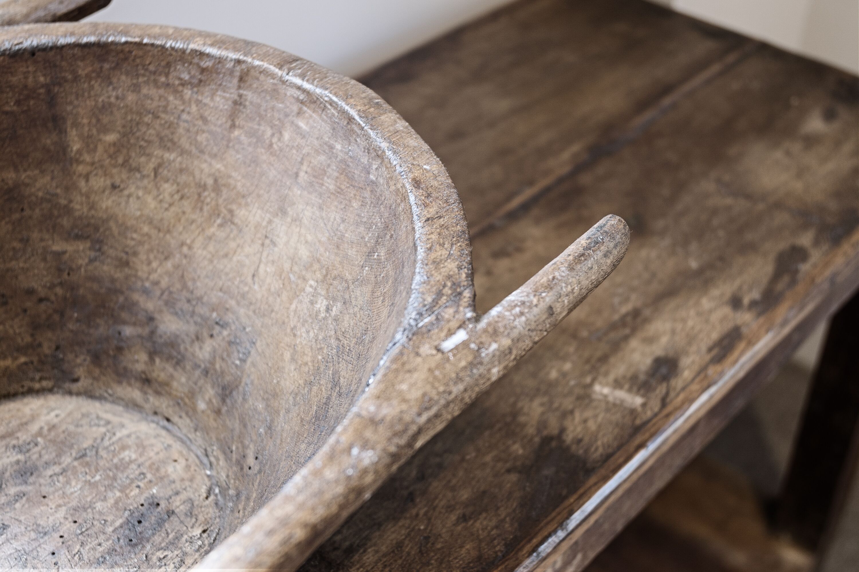 A rustic wooden table with a worn surface and a handle.