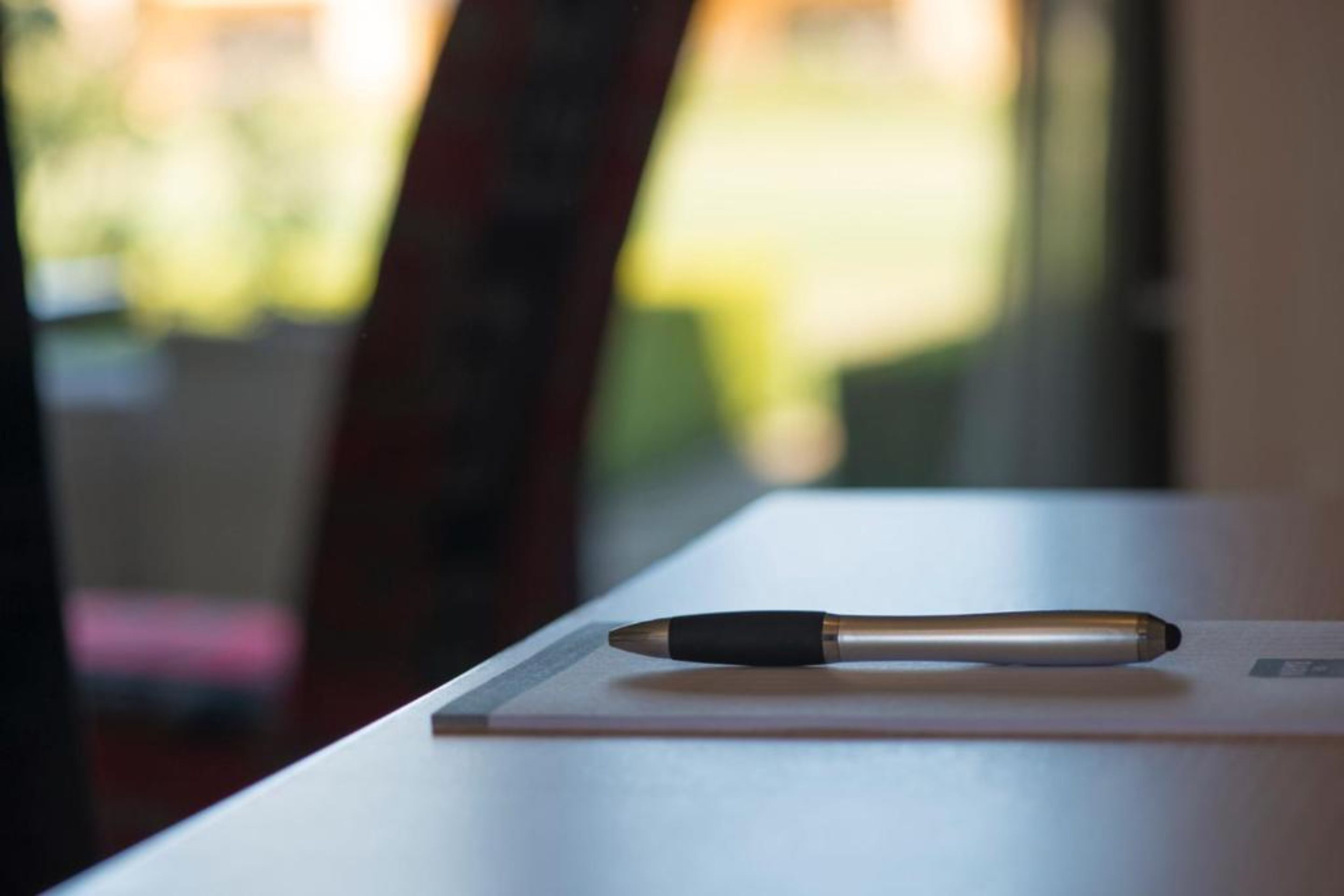 A pen on a white surface with a blurred background.