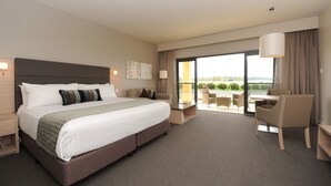 A modern hotel room with a large bed, a desk, and a view of the outdoors. - The Barn Accommodation (Ob Flat)