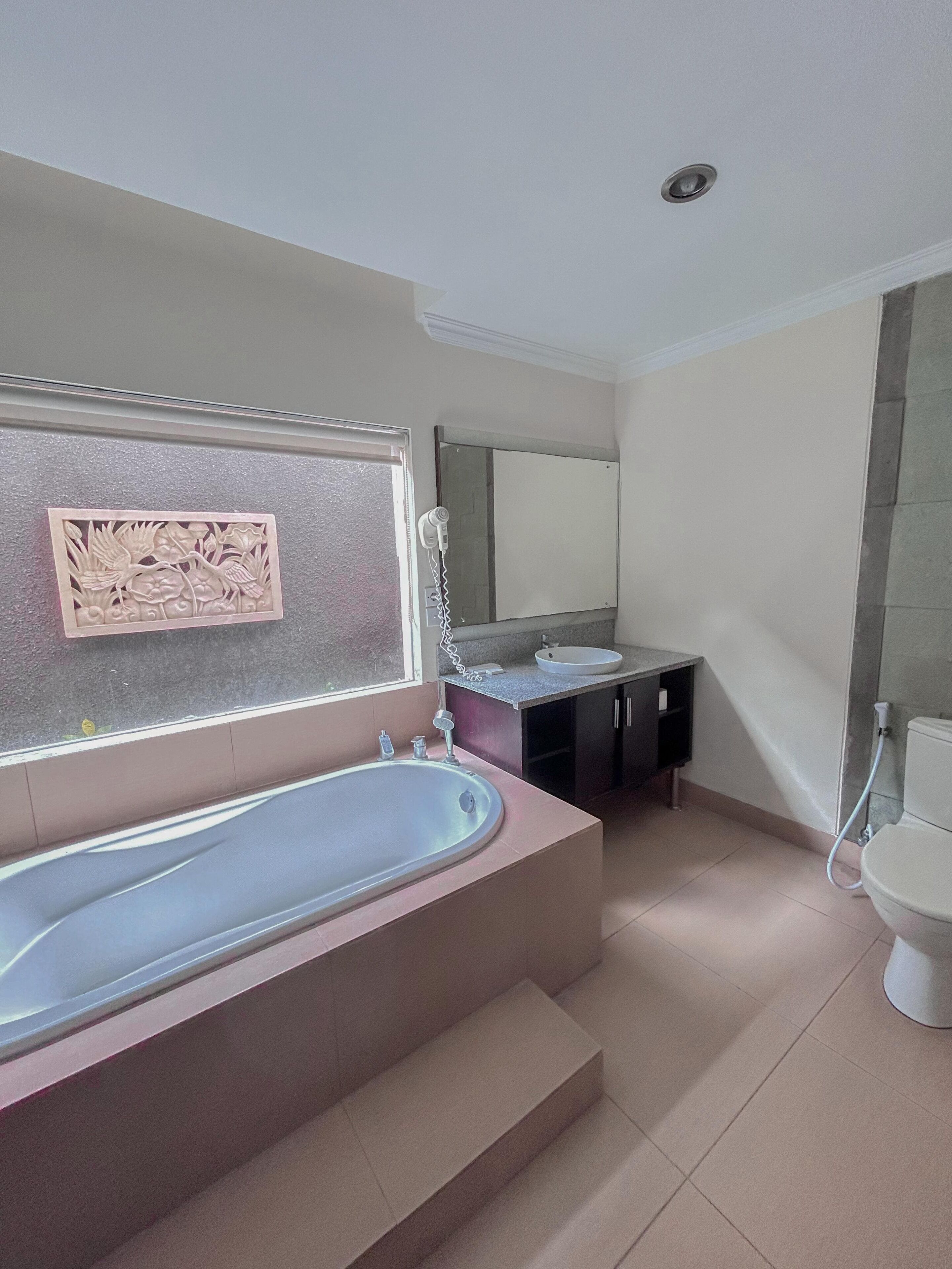 Une salle de bain moderne avec une baignoire sur pieds, un meuble-lavabo avec un miroir et des toilettes.