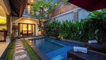 Alberca techada, alberca al aire libre y sombrillas en la alberca