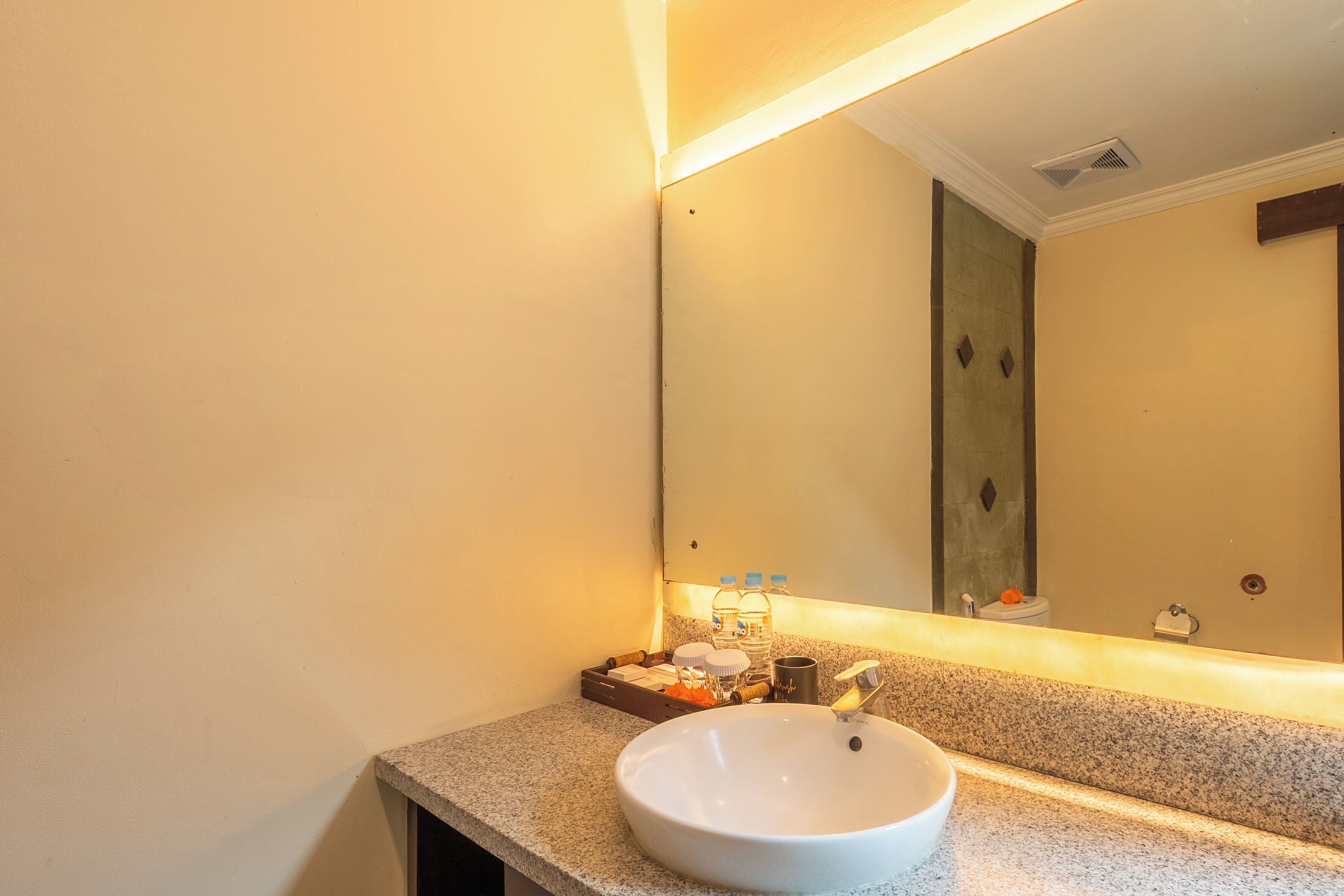 A bathroom with a white sink, a mirror, and a towel rack.