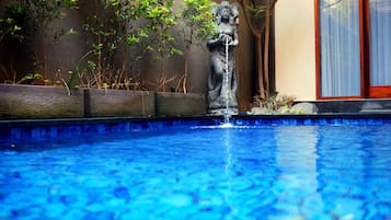 Una piscina techada, una piscina al aire libre, sombrillas