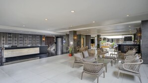 A spacious lobby with a reception desk, wicker furniture, and a modern bar area. - Hotel Solaris Kuta Bali (Kuta)