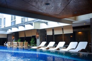 Una piscina al aire libre, tumbonas