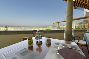 A table set for dining with a view of a cityscape. - Villa Tolomei Hotel & Resort (Florence)