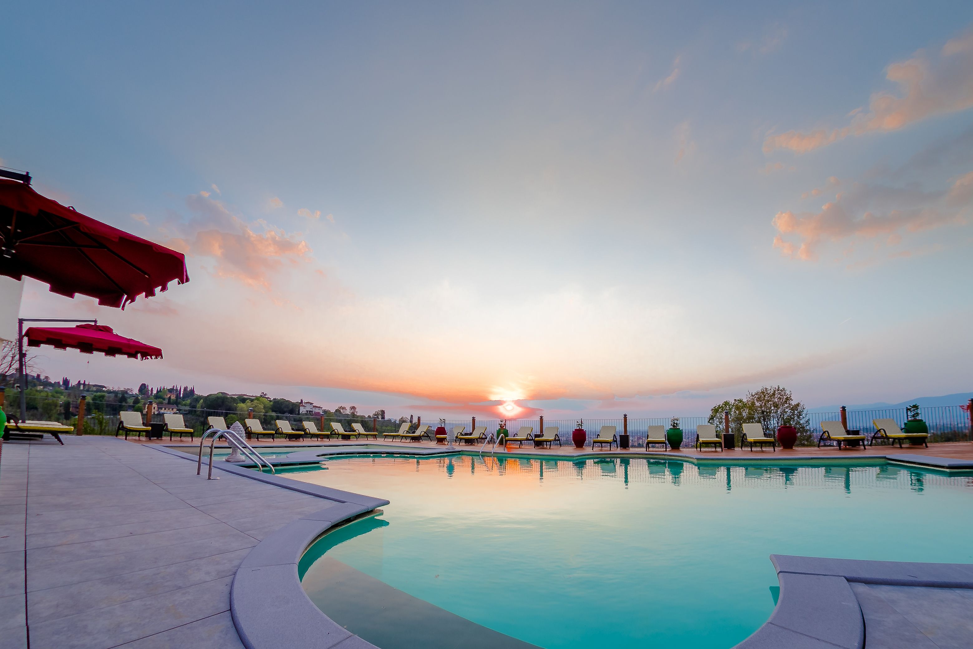 Una piscina al aire libre de temporada, sombrillas