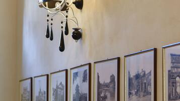 A wall with framed black and white photographs of various buildings and landmarks.