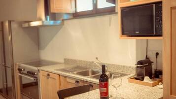 Una cocina con encimera de granito, una botella de vino y una copa de vino.