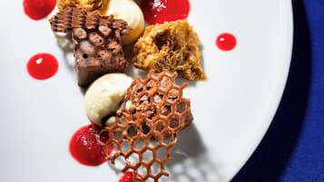 Un plato de postres con diferentes dulces y salsa roja.