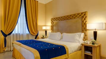Ein Hotelzimmer mit einem großen Bett, zwei Nachttischlampen, einem Nachttisch mit Lampe und einem Fenster mit Vorhängen.