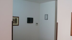 A room with a wooden table and chairs, white walls, and a framed picture on the wall. - Catania Crossing B&B Rooms and Comforts (Catania)