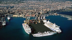 A large cruise ship docked at a port with a cityscape and a mountain in the background. - Catania Crossing B&B Rooms and Comforts (Catania)