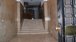 A marble staircase leading to a room with a chandelier, a wooden door with a brass handle, and a patterned glass door. - Catania Crossing B&B Rooms and Comforts (Catania)