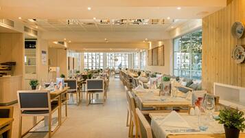 A restaurant with wooden furniture, large windows, and a long counter.