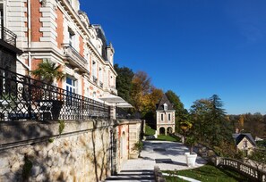 A historic building with a stone facade, a paved courtyard, and a small tower.