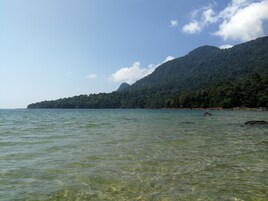 Una vista despejada de la costa con una montaña al fondo.