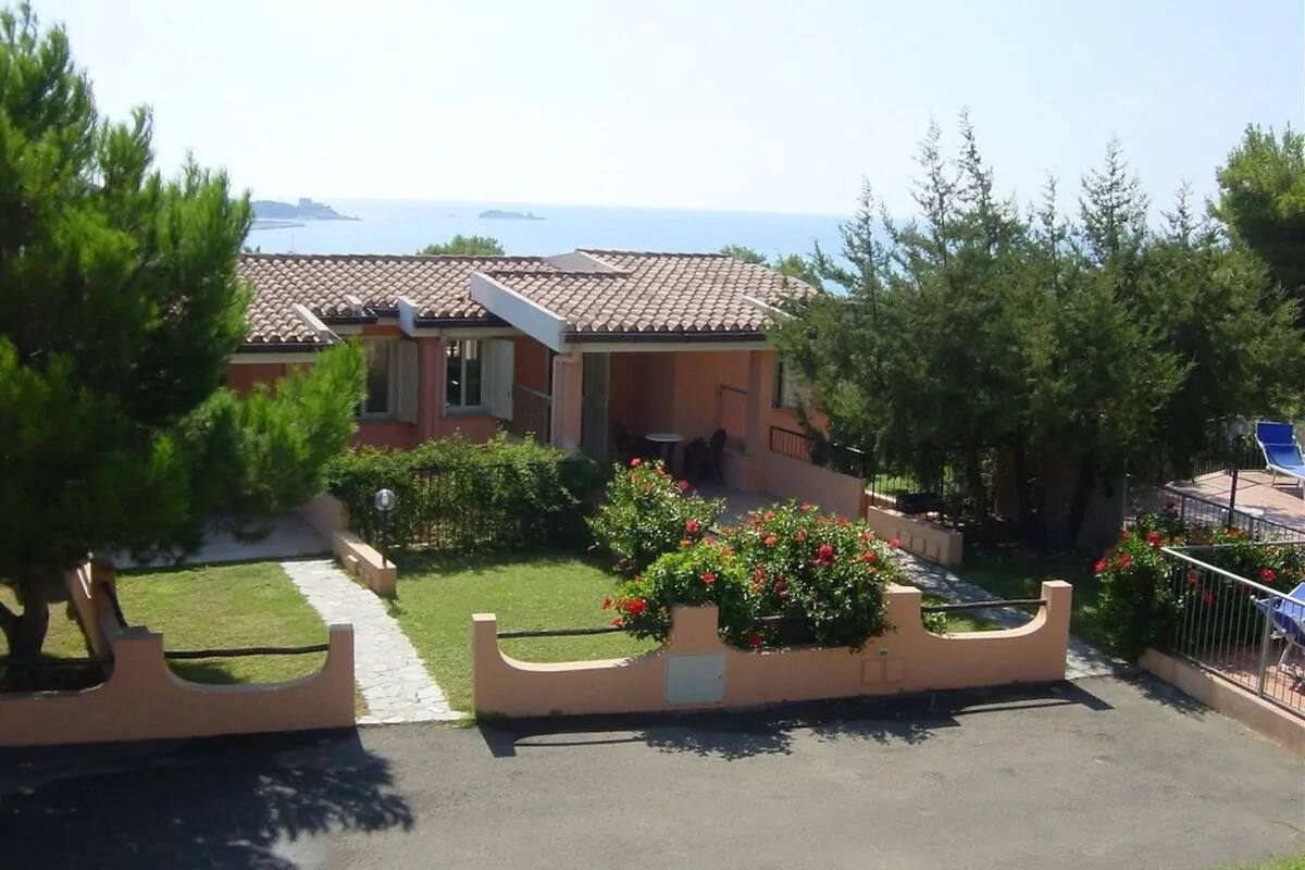 A residential property with a garden, a pathway, and a view of the sea.