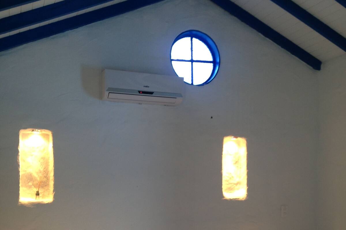 Una habitación con dos camas, una ventana y un equipo de aire acondicionado.