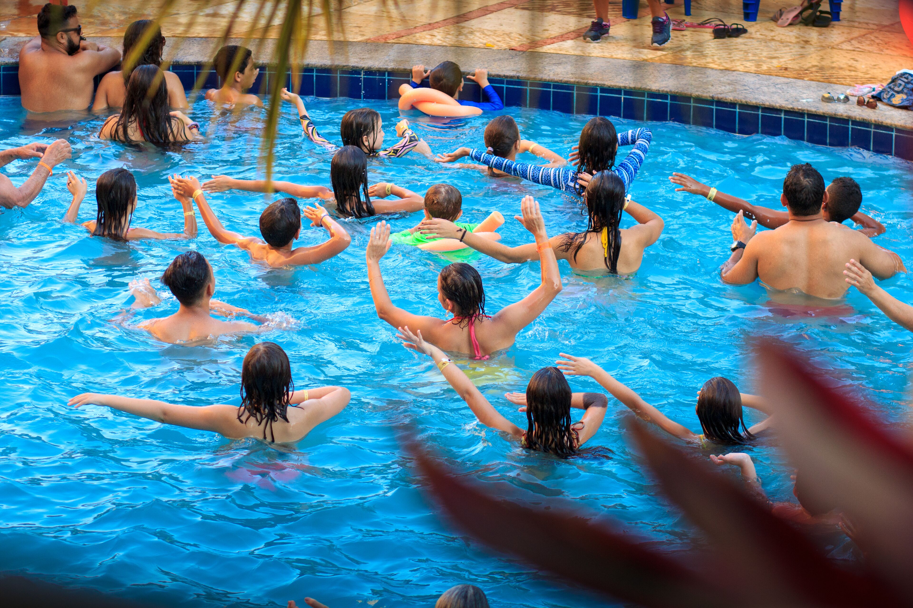 A swimming pool with multiple people enjoying the water.
